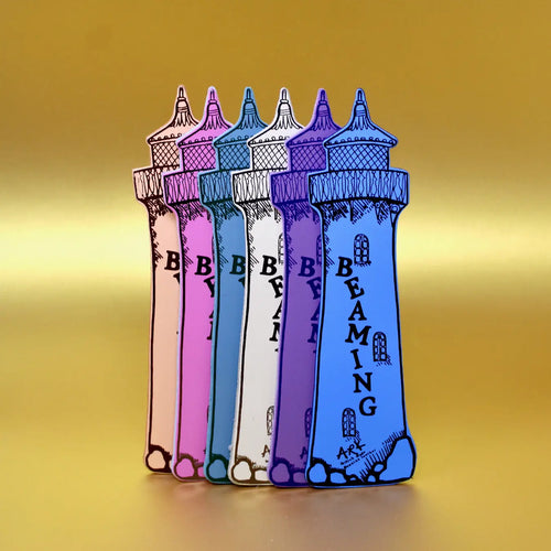 Set of colorful Ark Colour Design leather bookmarks shaped like lighthouses with the text 'Beaming' on the back, shown standing together on a yellow background.