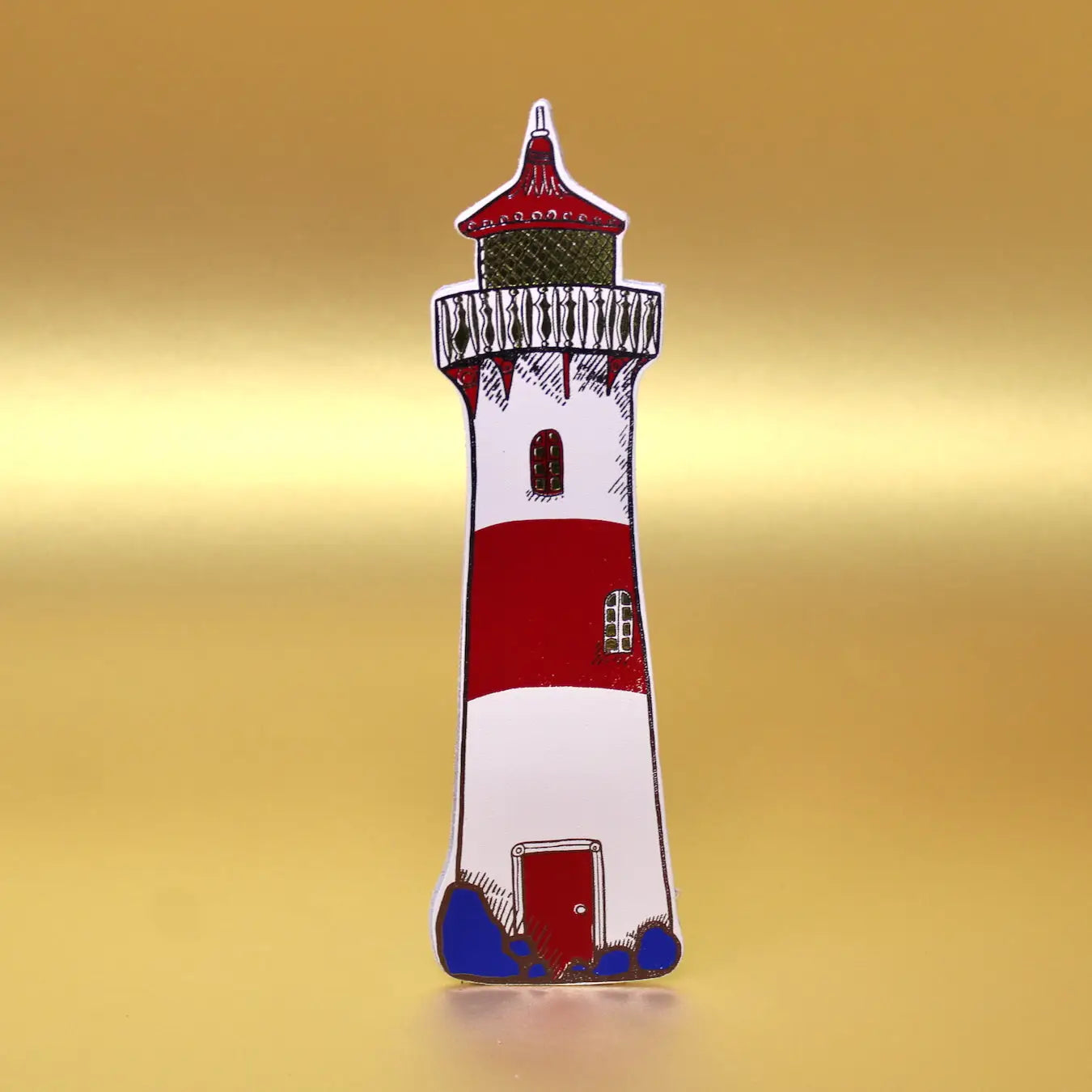 Cream lighthouse-shaped leather bookmark from an Ark Colour Design book, shown standing on a gold background.