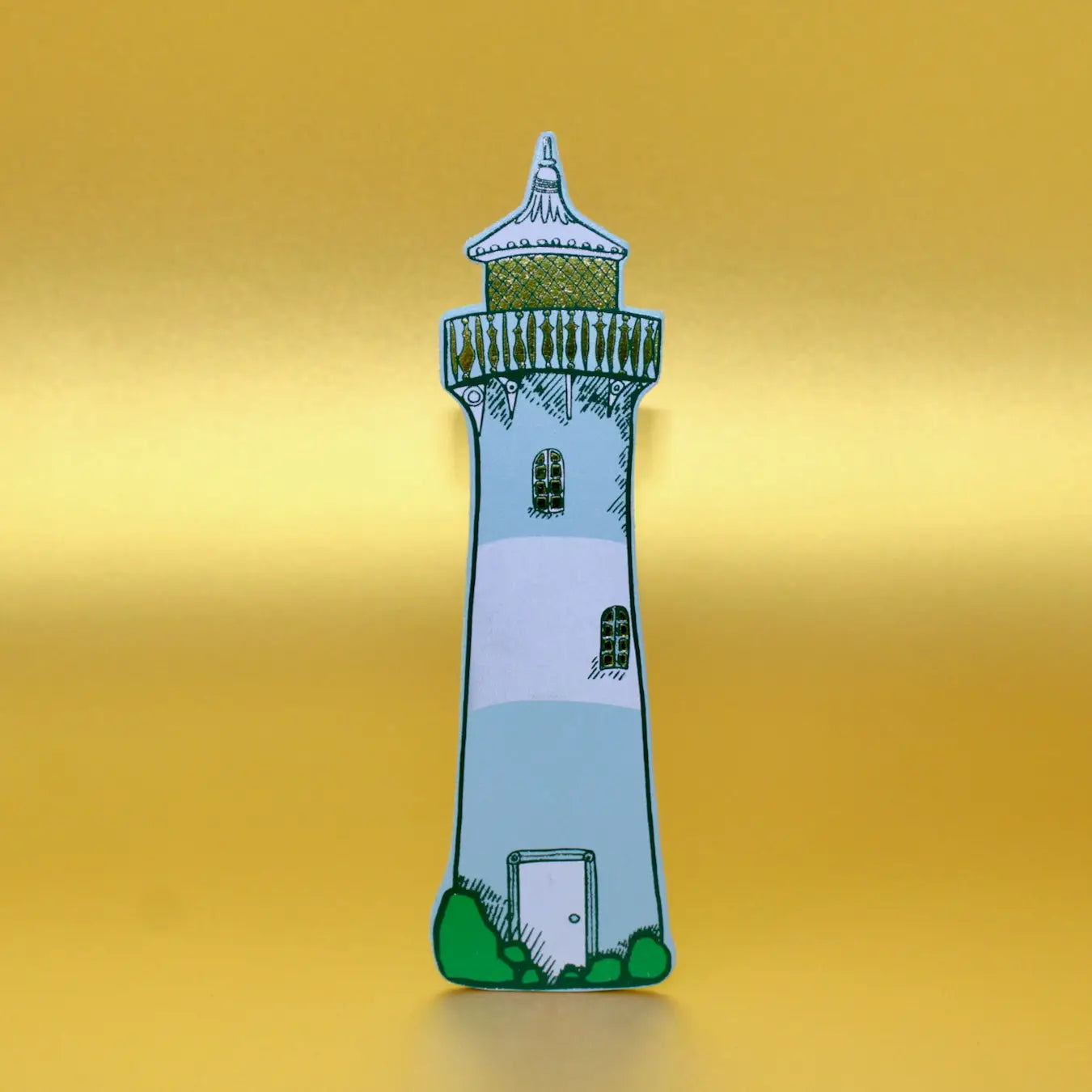 Duck egg blue lighthouse-shaped leather bookmark from an Ark Colour Design book, shown standing on a gold background.