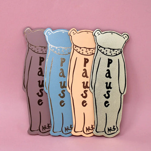 The back of four Ark Colour Design leather bookmarks shaped like bears with the text 'PAUSE' on them, shown in different colors on a pink background.