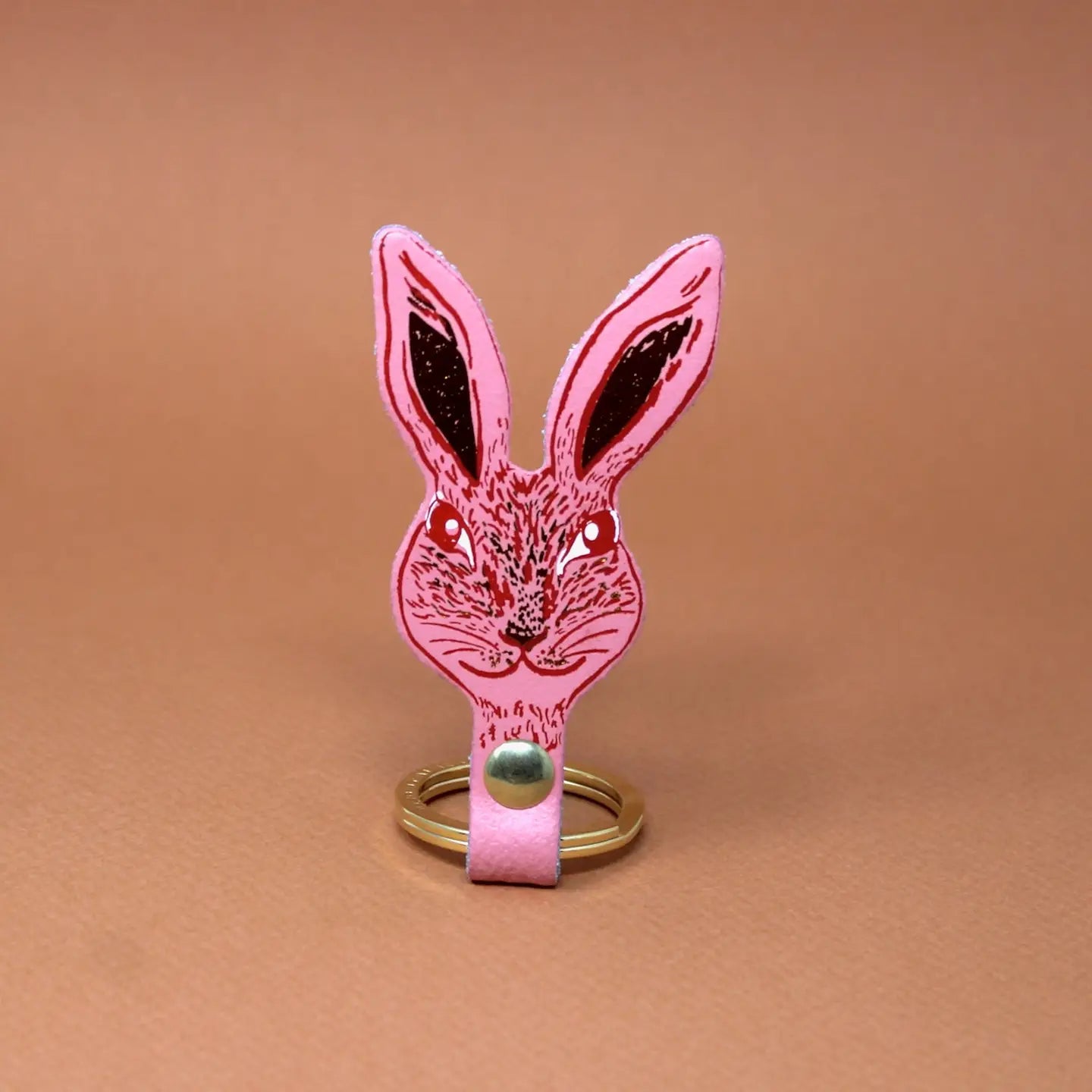 Ark Colour Design rabbit keychain in pink with a gold ring and detailed rabbit face illustration.