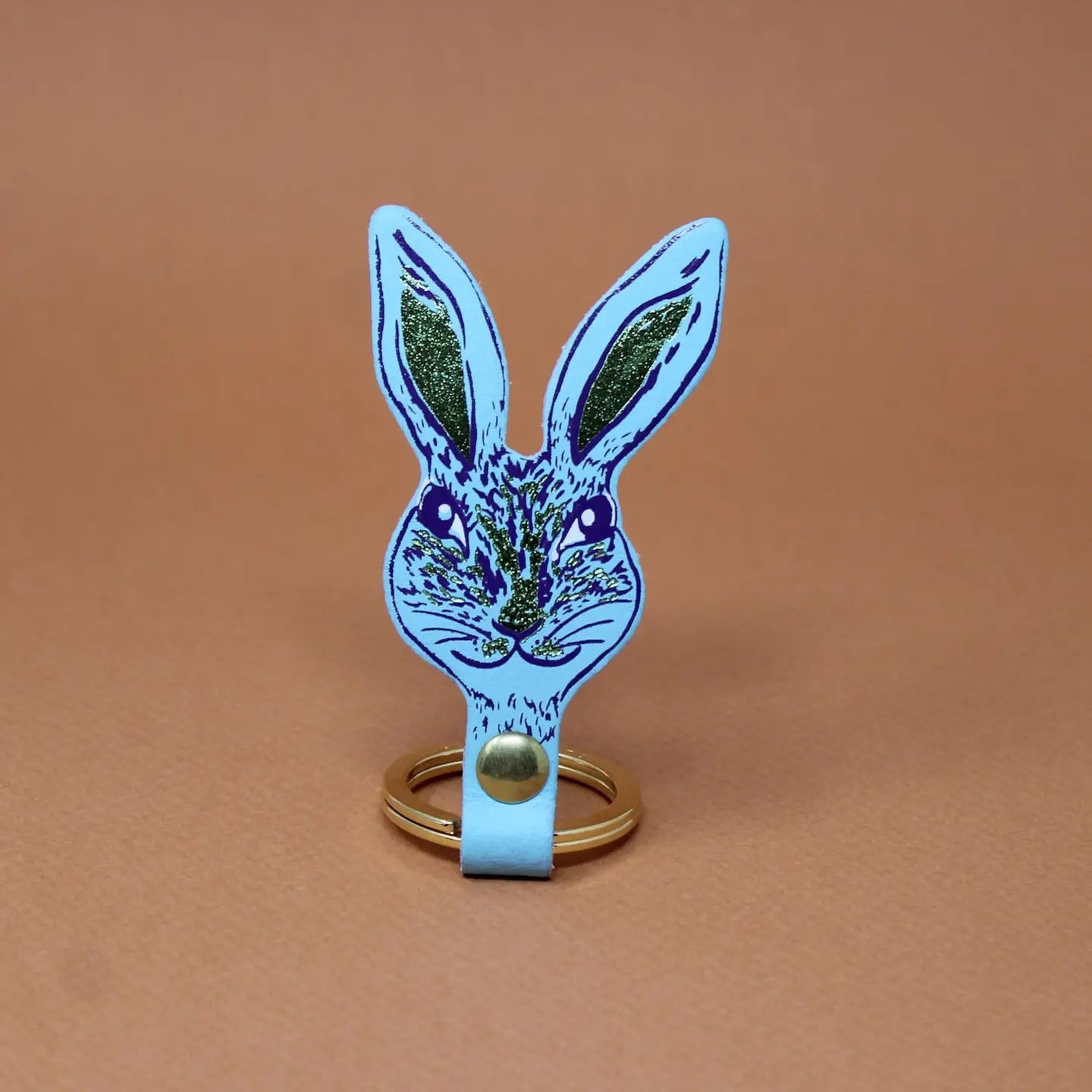 Ark Colour Design rabbit keychain in turquoise with a gold ring and detailed rabbit face illustration.