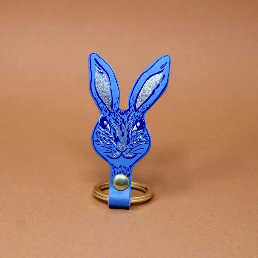 Ark Colour Design rabbit keychain in blue with a gold ring and detailed rabbit face illustration.