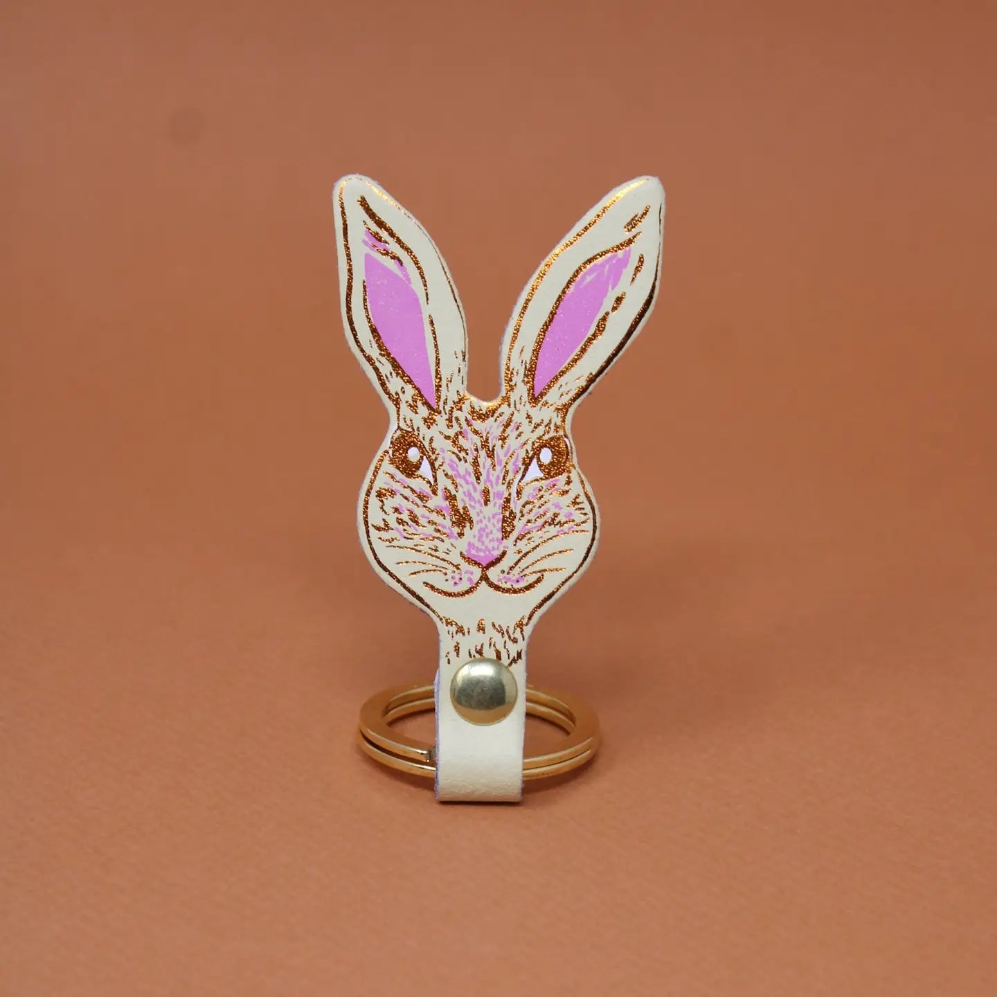 Ark Colour Design rabbit keychain in cream with a gold ring and detailed rabbit face illustration.