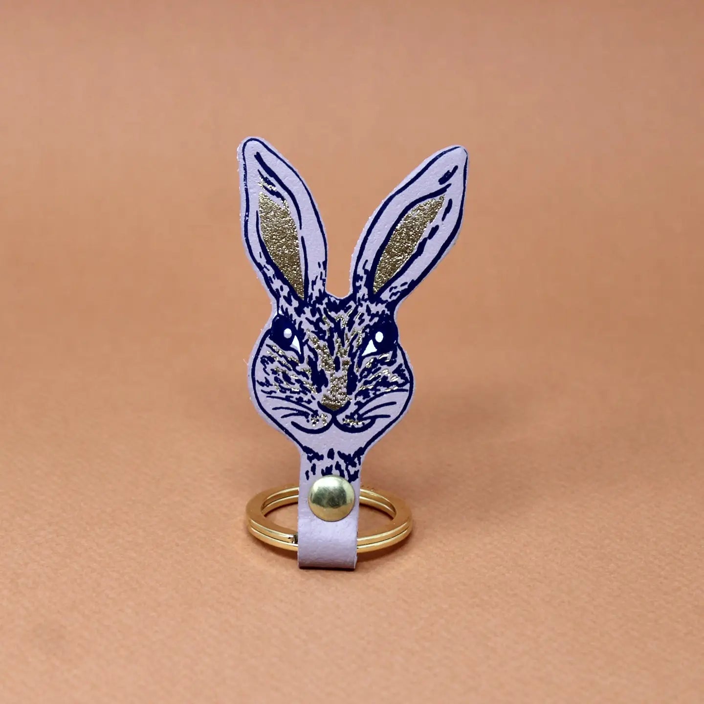 Ark Colour Design rabbit keychain in nude with a gold ring and detailed rabbit face illustration.