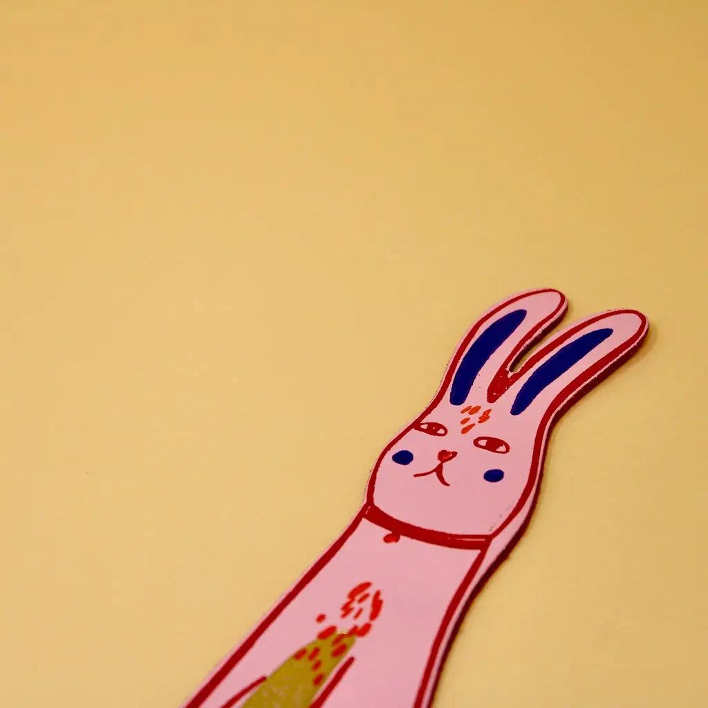 Pink Ark Colour Design rabbit bookmark with illustrated bunny face on a beige background