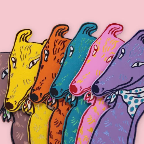 Greyhound-shaped bookmarks in brown, yellow, orange, teal, pink, and purple, with a spotted bandana detail on the purple dog, fanned out on a pink background.