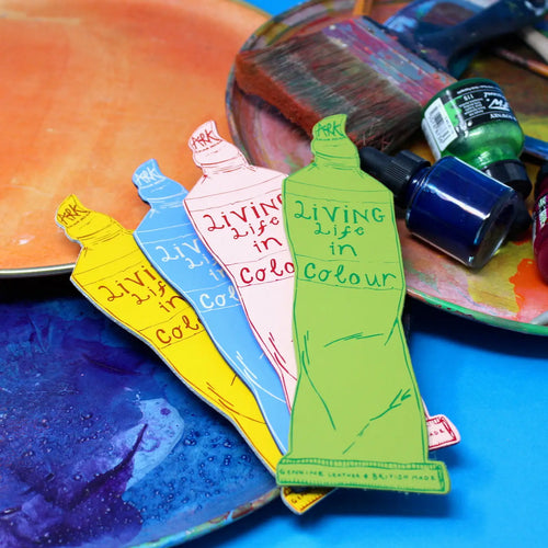 Ark Colour Design paint tube bookmarks with “Living Life in Colour” lettering, shown with art palettes and paint bottles