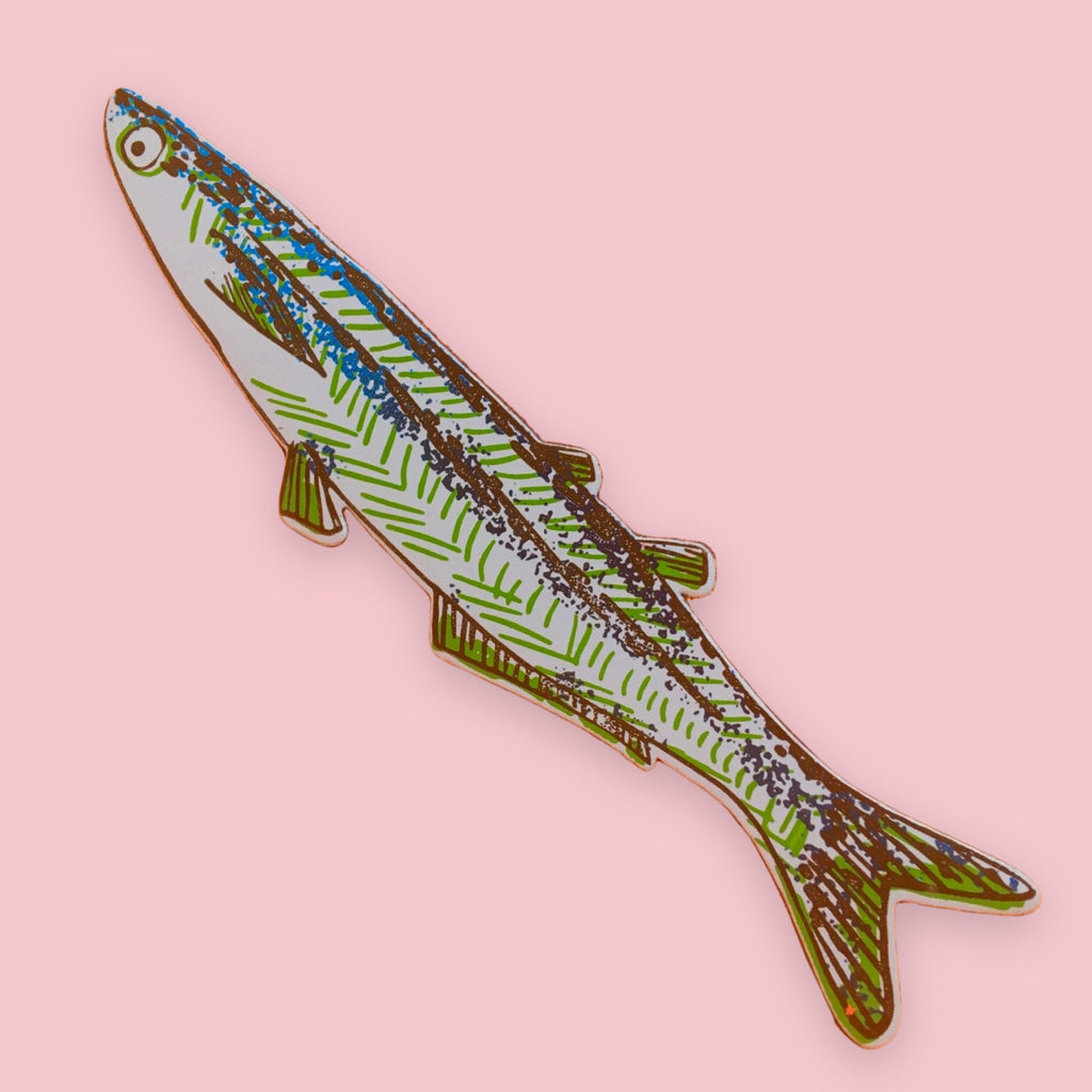 Light blue fish-shaped bookmark with green, blue, and brown patterned stripes, on a pink background.