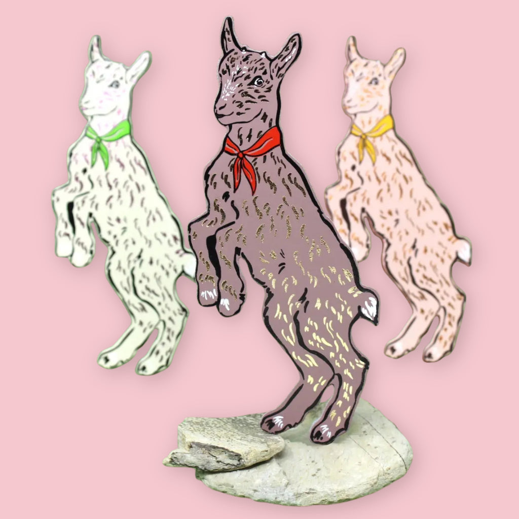 Three Ark Colour Design goat-shaped bookmarks with colorful neckerchiefs on a pink background