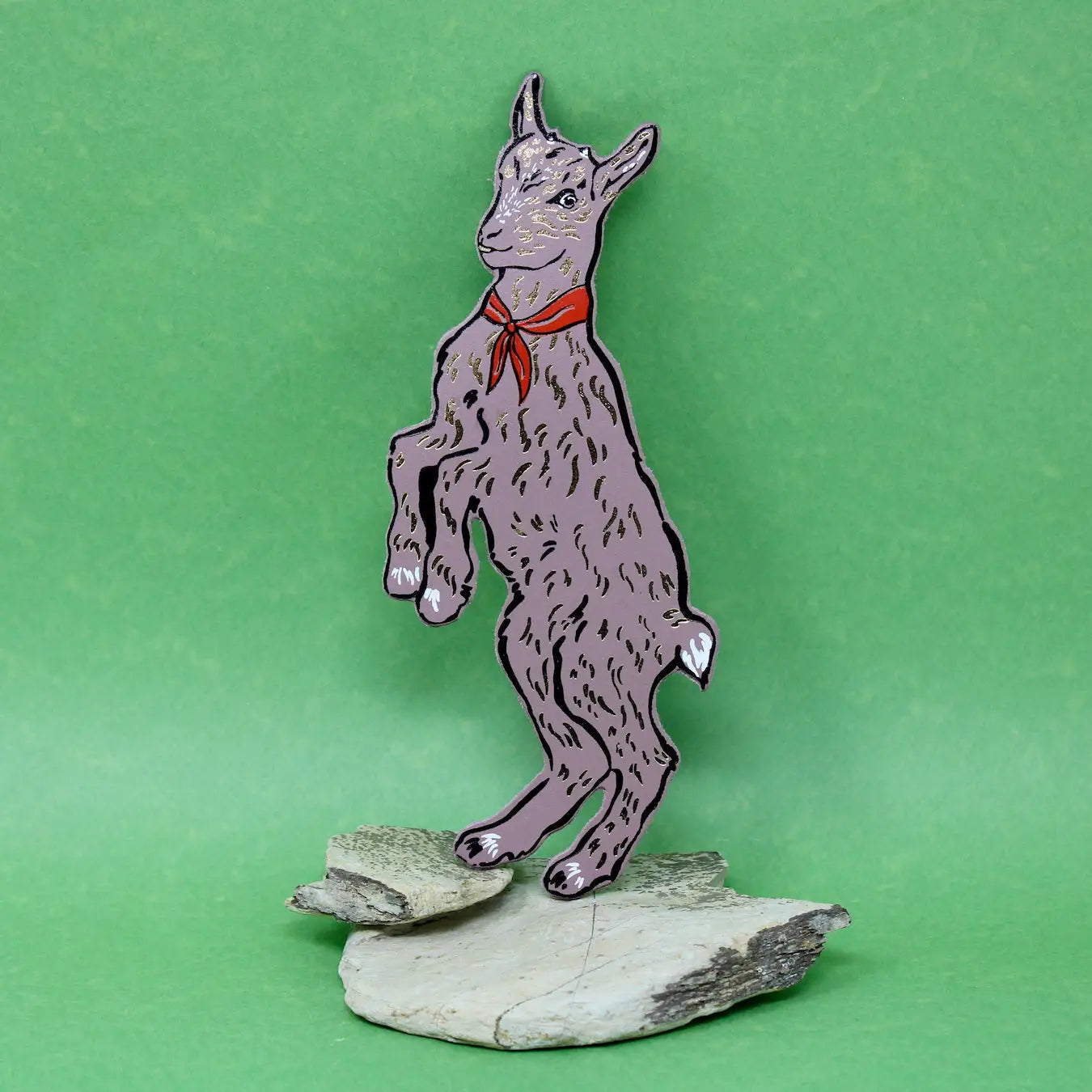 Ark Colour Design dusty pink goat-shaped bookmark with a green neckerchief, standing on a green background