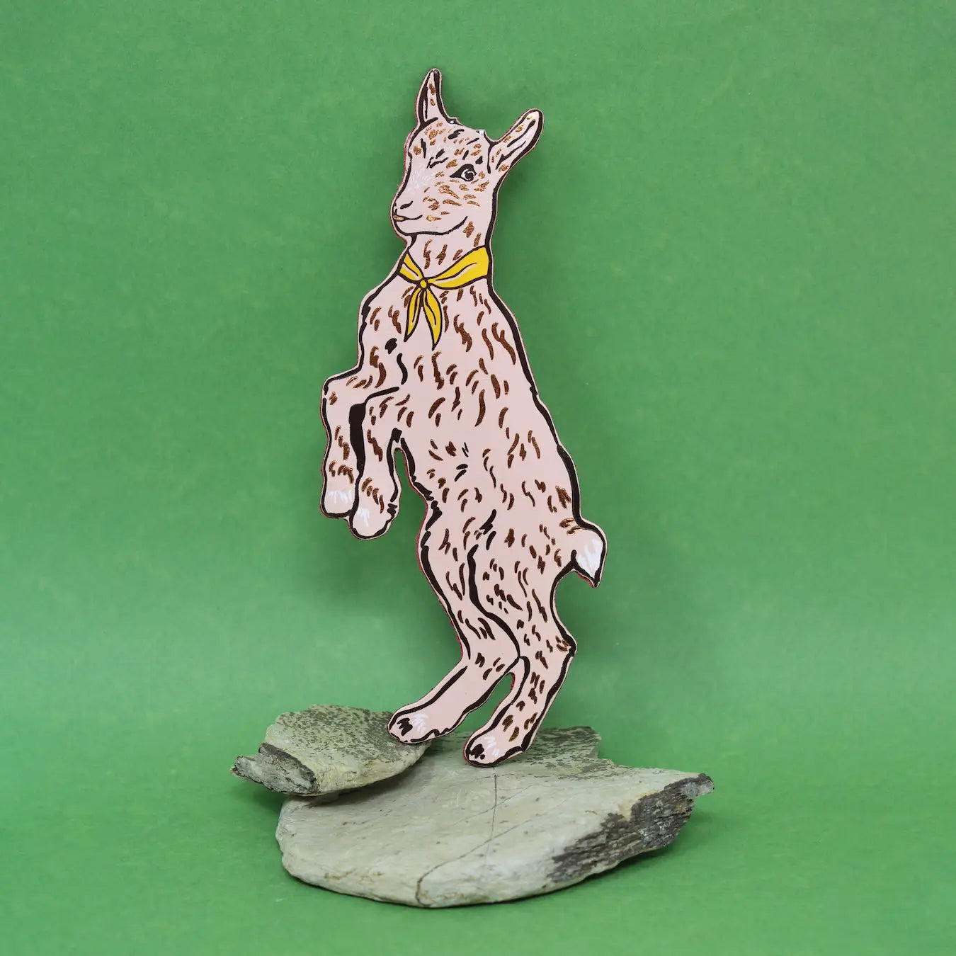 Ark Colour Design pale pink goat-shaped bookmark with a green neckerchief, standing on a green background