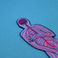 Close-up of a blue nervous system-shaped bookmark showing the brain and nerve pathways through the upper body, on a blue background.