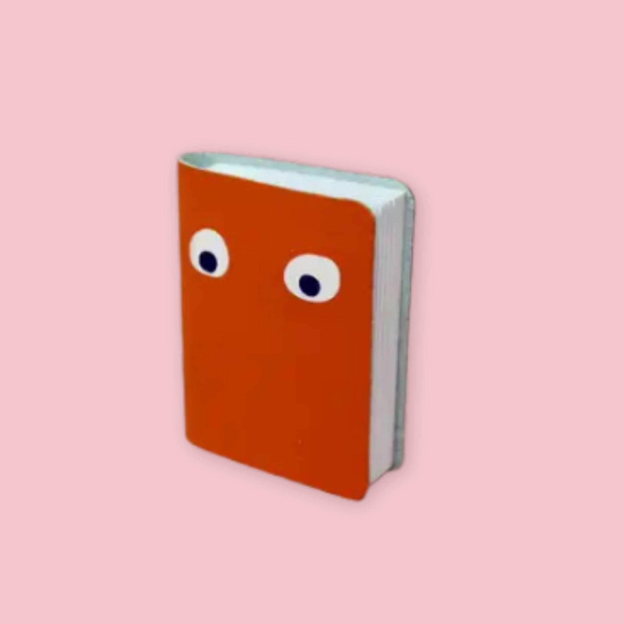 Ark Colour Design leather googly eye notebook in orange with foil-embossed eyes on a pink background