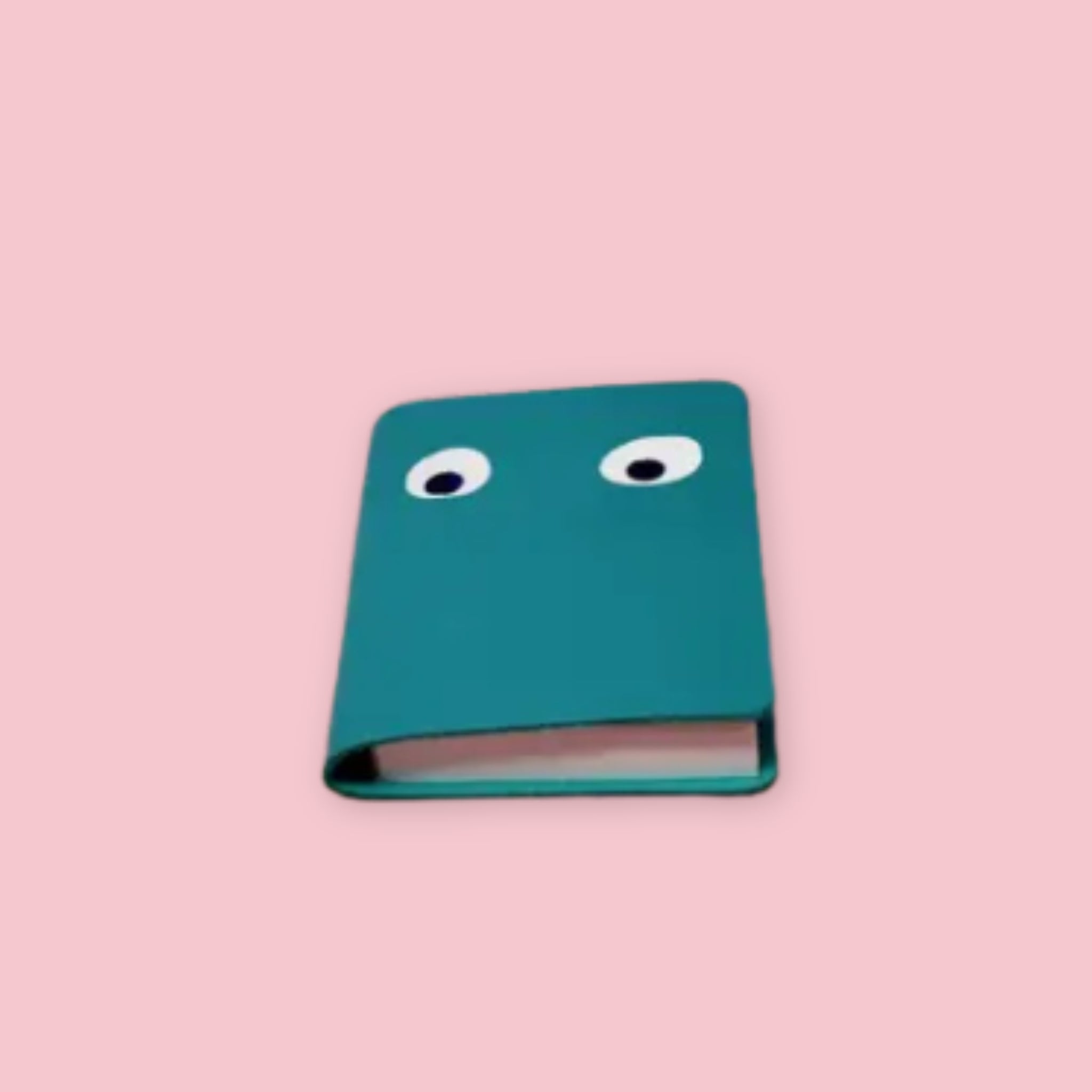Ark Colour Design leather googly eye notebook in turquoise with foil-embossed eyes on a pink background