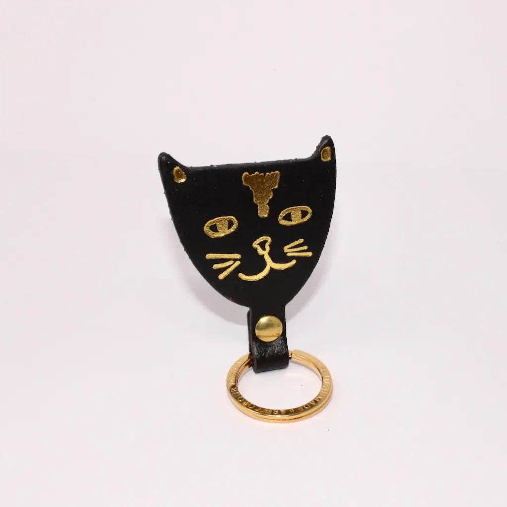 Ark Colour Design black cat keychain with a gold ring and hand-drawn gold cat face design.