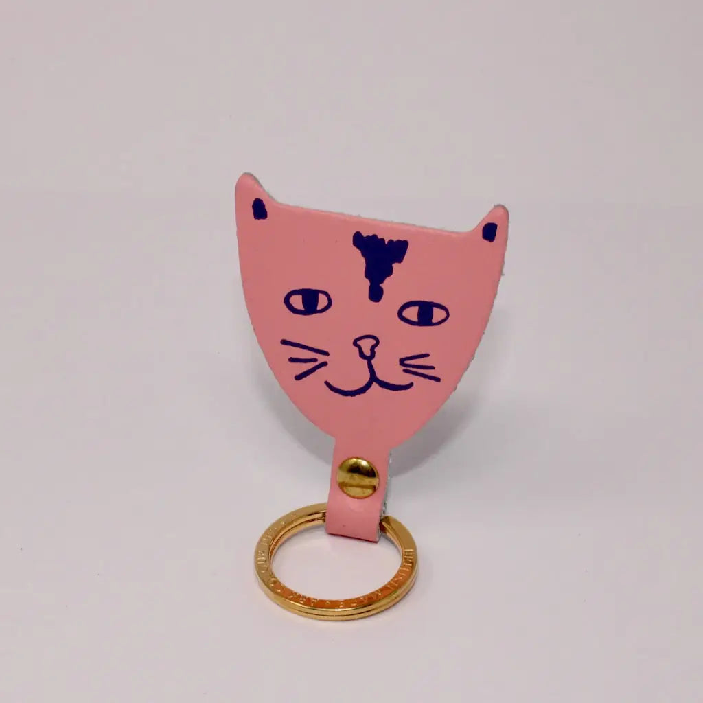 Ark Colour Design pink cat keychain with a gold ring and hand-drawn black cat face design.