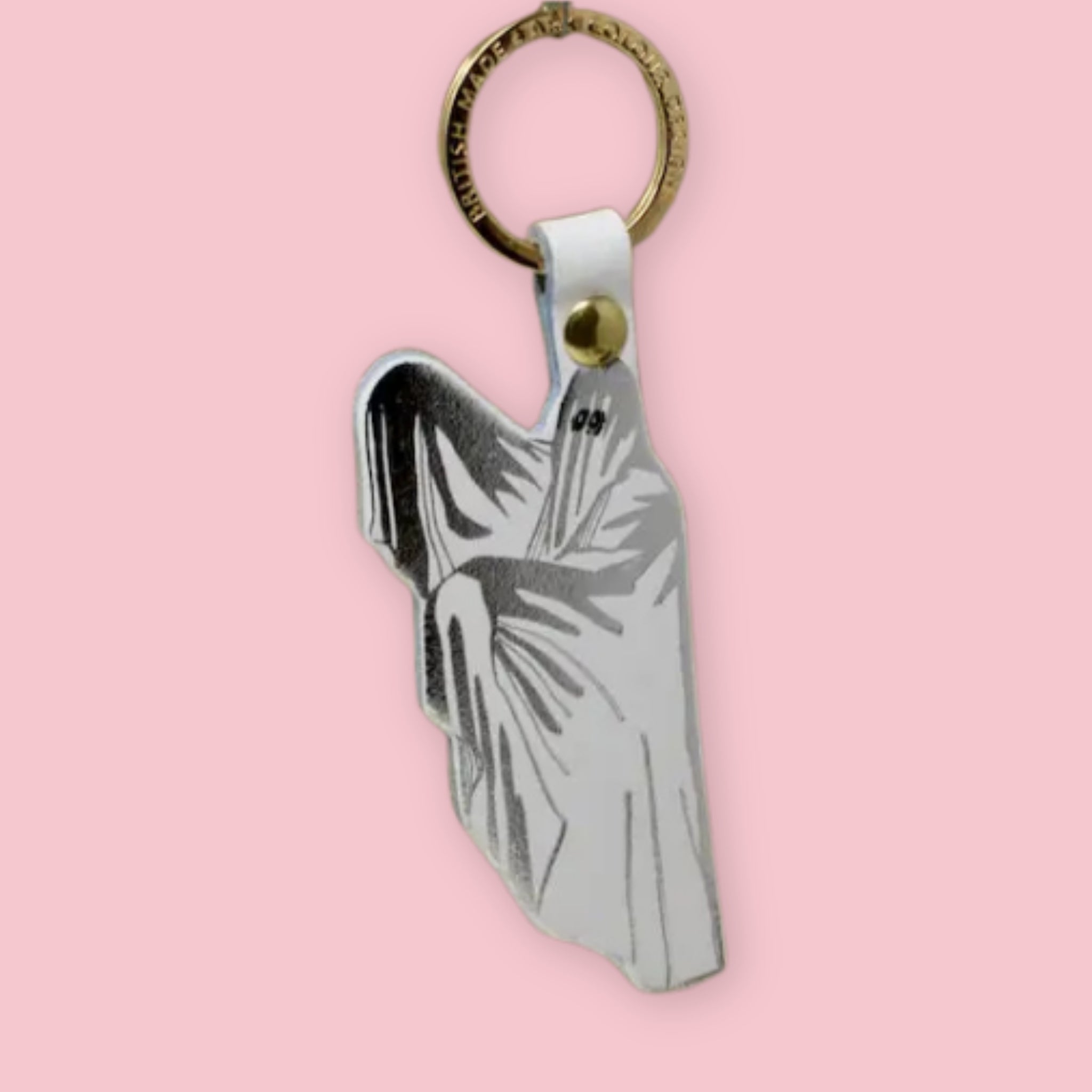 Ark Colour Design ghost keychain with white strap, gold ring, and silver-and-white ghost illustration on a pink background.
