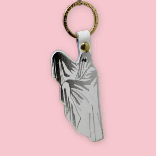 Ark Colour Design ghost keychain with white strap, gold ring, and silver-and-white ghost illustration on a pink background.