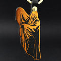 Ark Colour Design ghost keychain with black leather strap, gold ring, and orange ghost illustration on a black background.