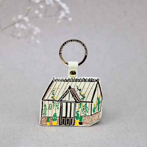 Ark Colour Design greenhouse keychain with yellow strap, gold ring, and illustrated cream greenhouse design.