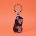 Ark Colour Design guinea pig keychain with a gold ring and illustrated black, nude beige, and tan guinea pig design.