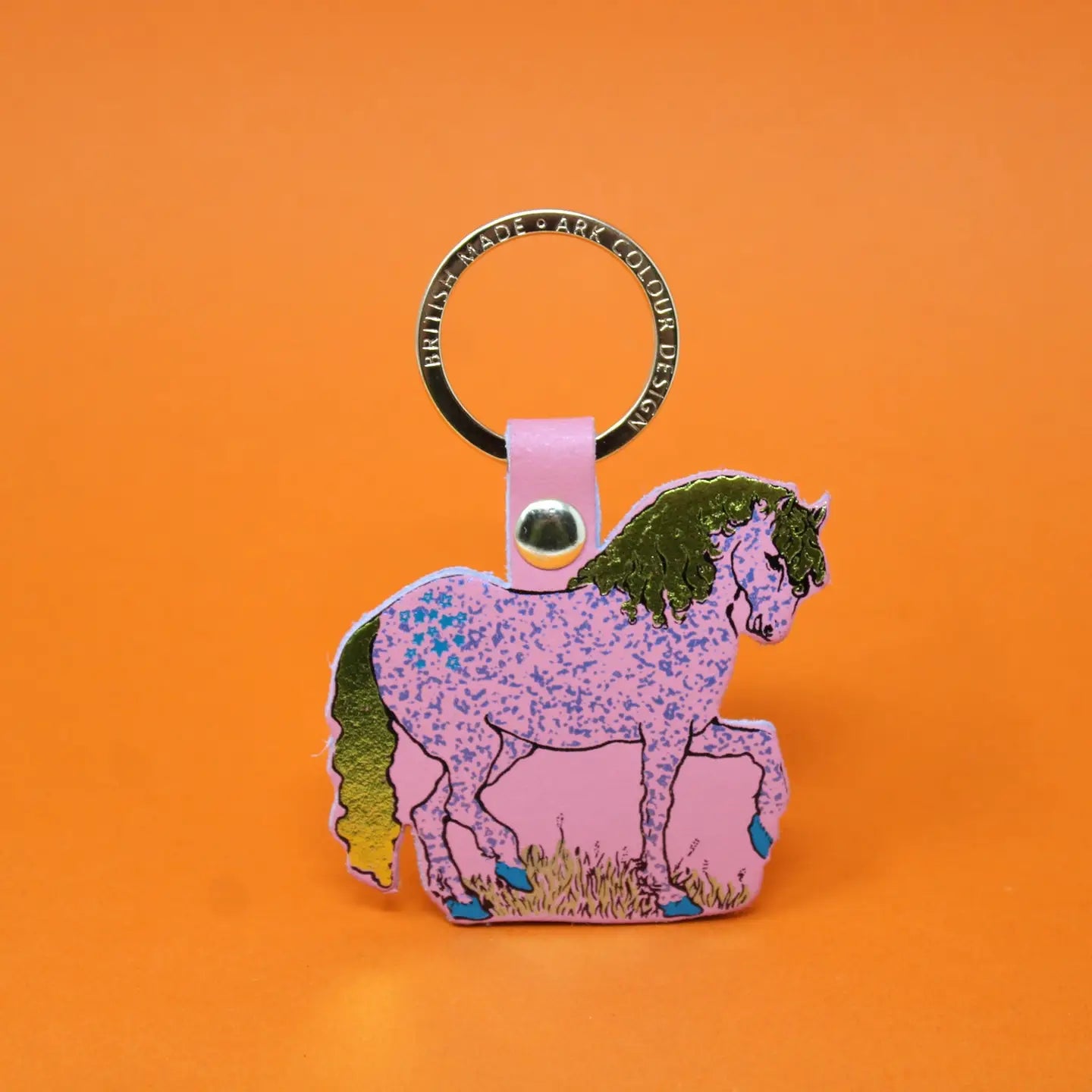 Ark Colour Design horse keychain with gold ring, pink leather loop, and illustrated pink horse design on an orange background.