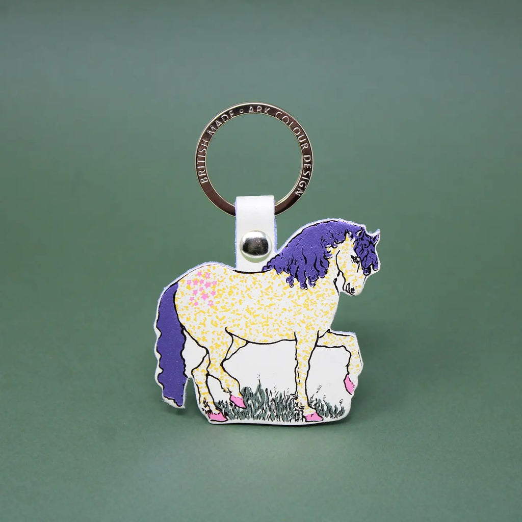 Ark Colour Design horse keychain with gold ring, cream leather loop, and illustrated cream horse design on a green background.