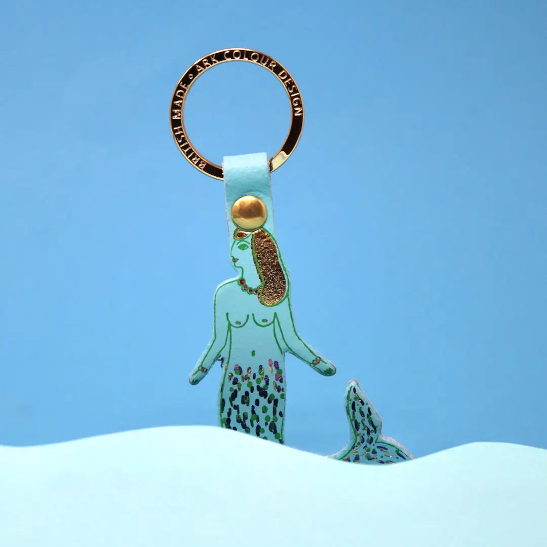 Blue  ermaid keychain with gold accents on a blue background