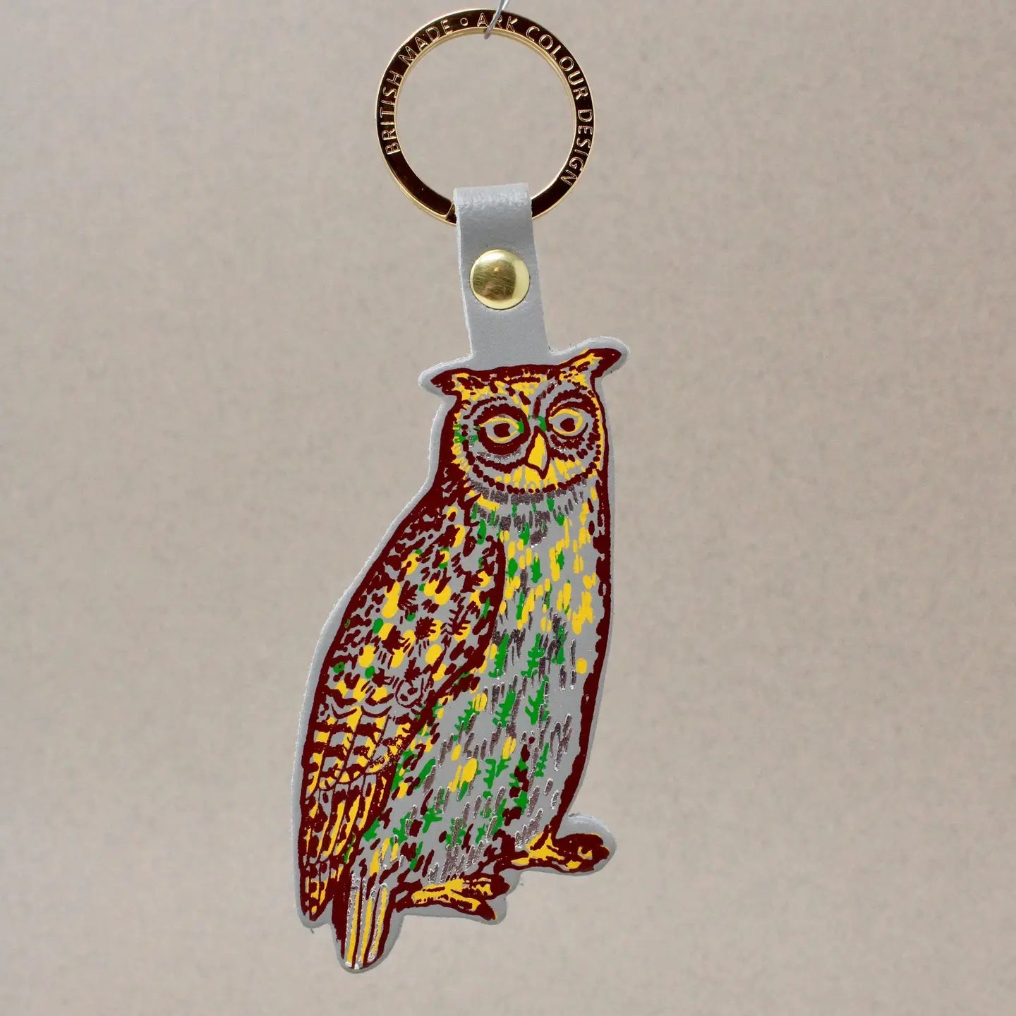 Ark Colour Design owl keychain with gold ring, gray leather strap, and illustrated owl design.