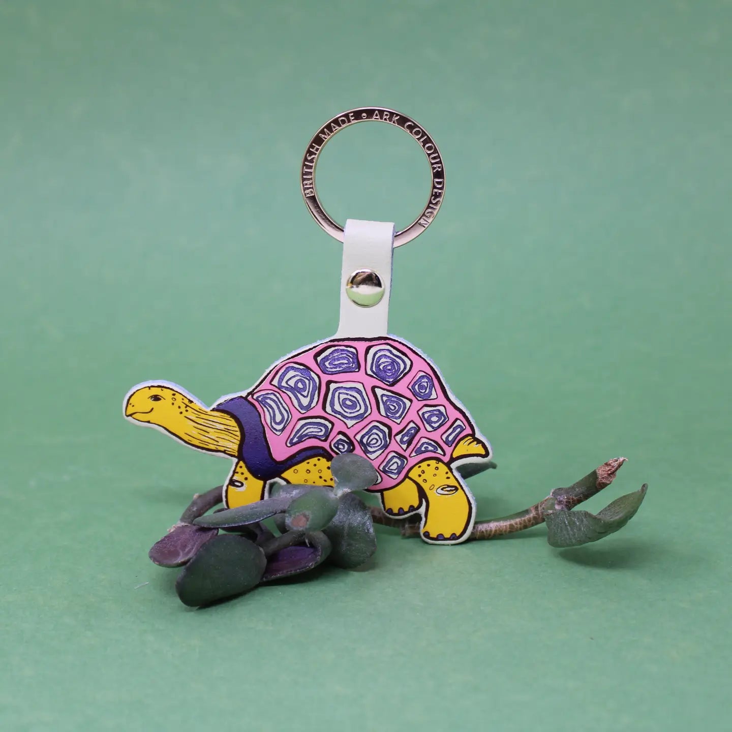 Ark Colour Design tortoise keychain with cream strap, gold ring, and colorful illustrated turtle design.