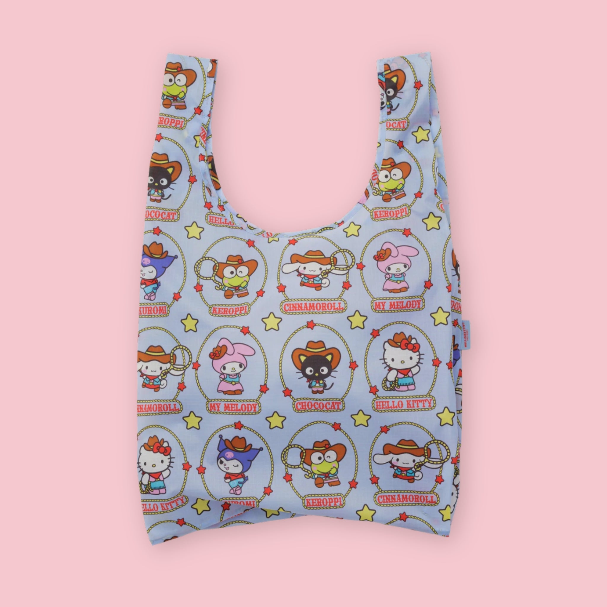 Baggu standard tote in the Hello Kitty & Friends Western print, featuring Hello Kitty, My Melody, Cinnamoroll, Chococat, Kuromi, and Keroppi in cowboy outfits inside lasso circles with stars, on a light blue background, on a pink background.