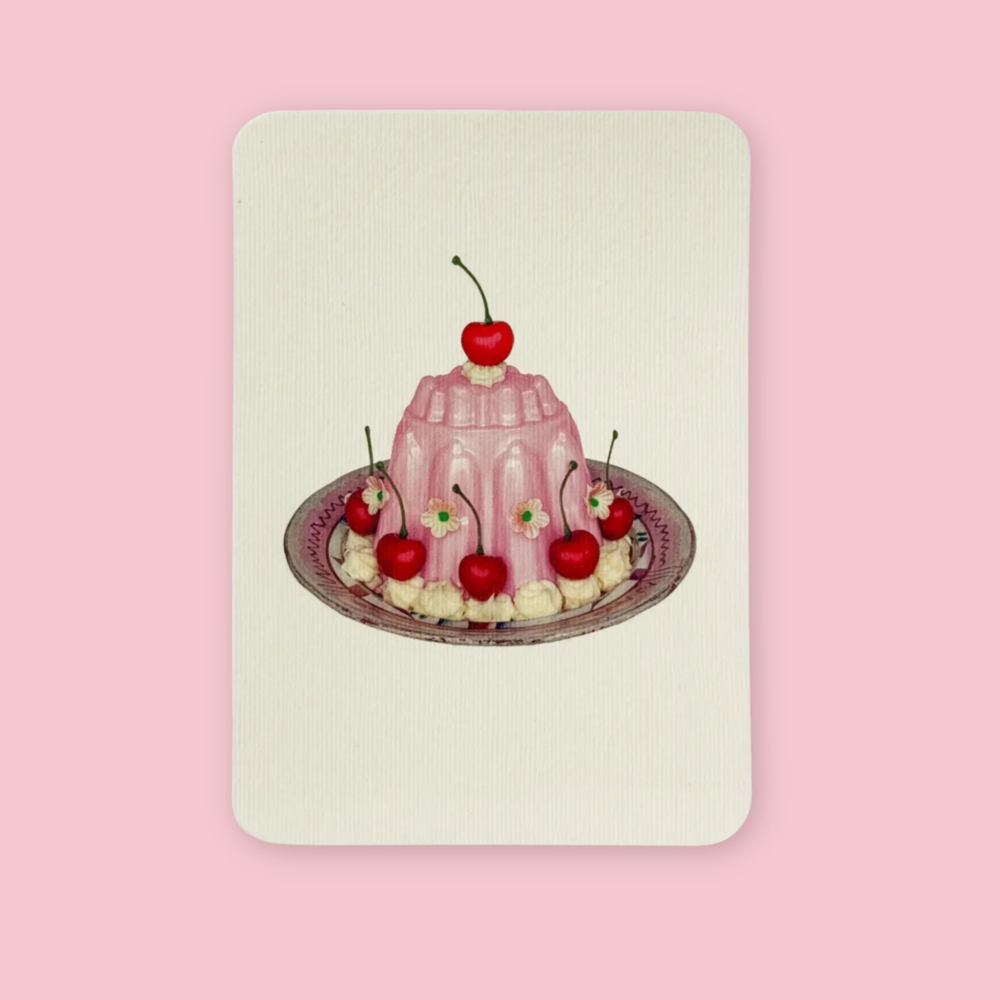 Canonbury Press Greeting card featuring an illustrated pink rose petal cream dessert topped with red cherries and small flowers on a decorative plate.