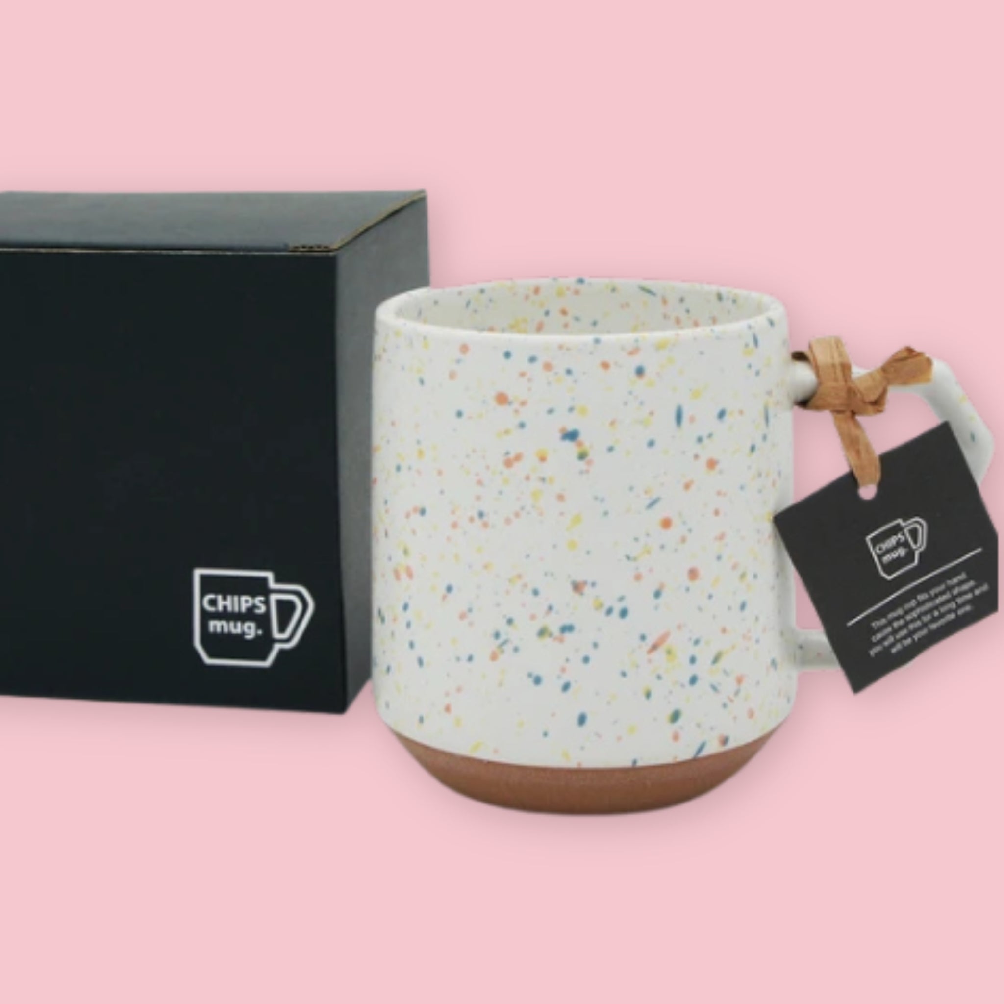 Chips Mug in Orange Splash with multicolor speckled glaze and branded black gift box on a pink background