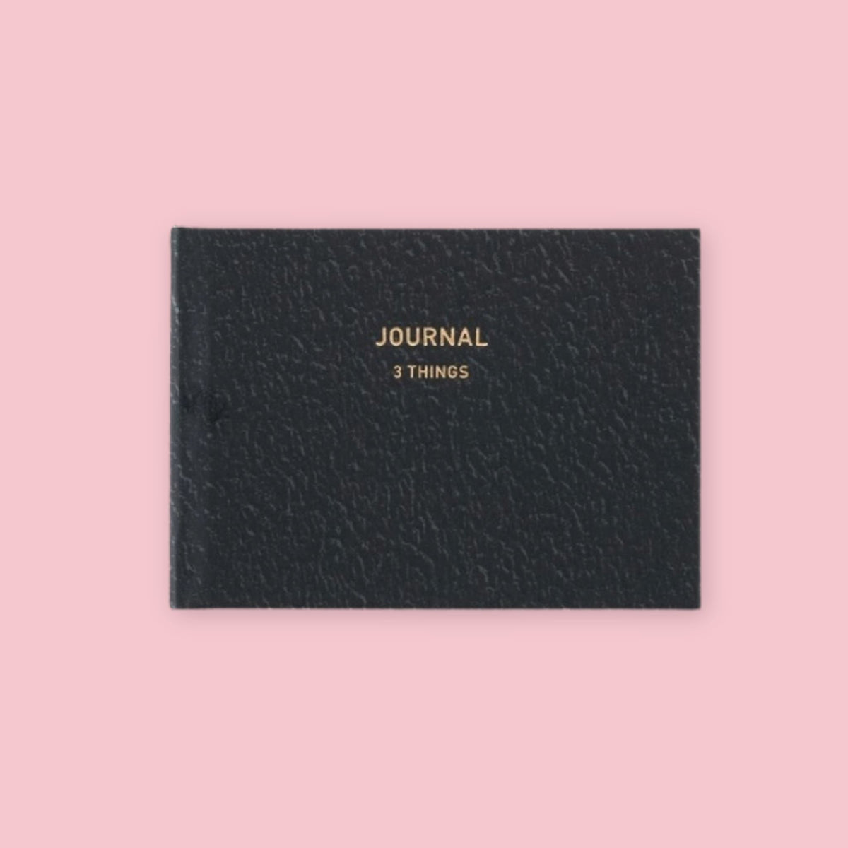 Black Daigo Mini Easy Journal 3 Things with gold lettering on a pink background.