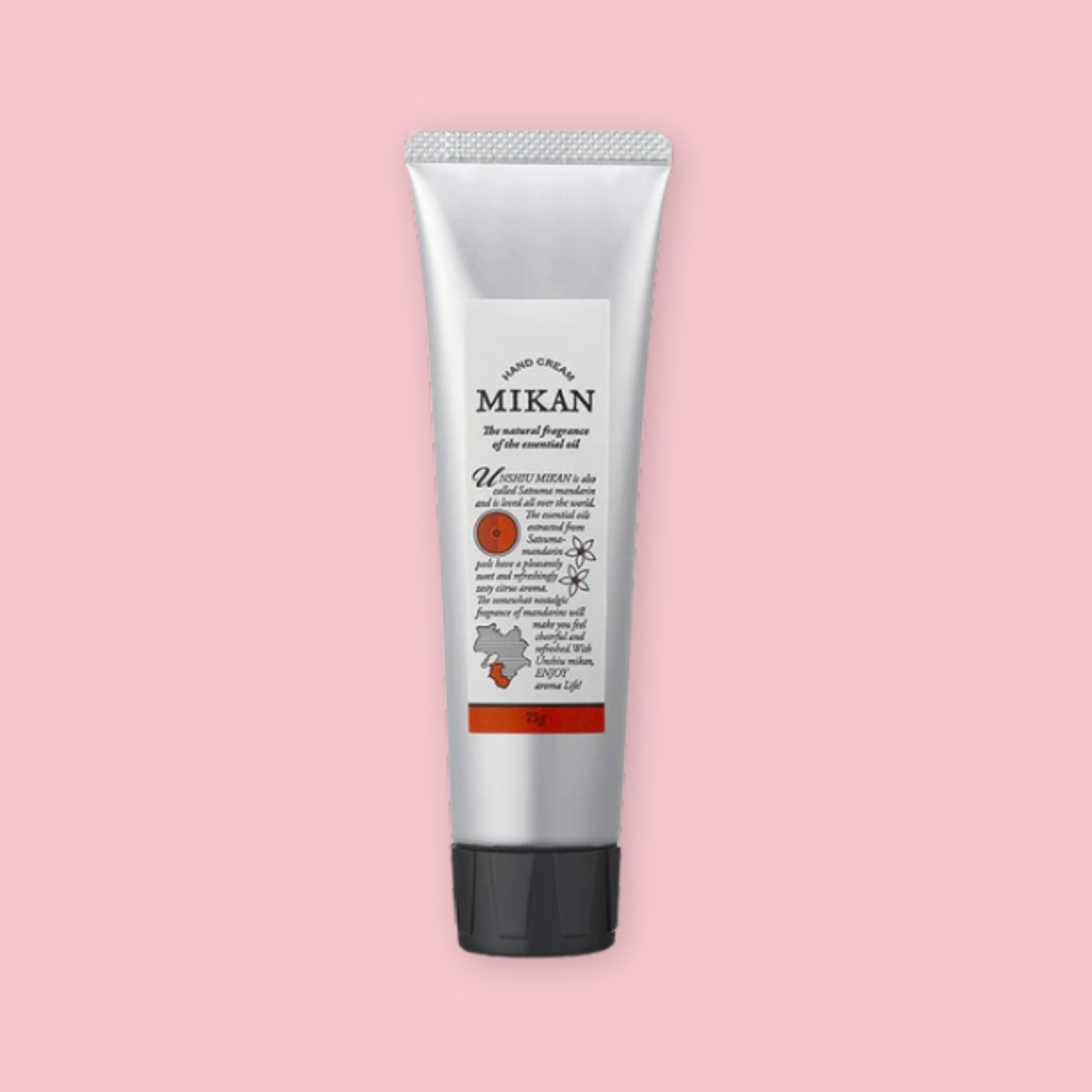 Silver tube of mikan hand cream with a black cap and orange label, shown upright on a pink background.
