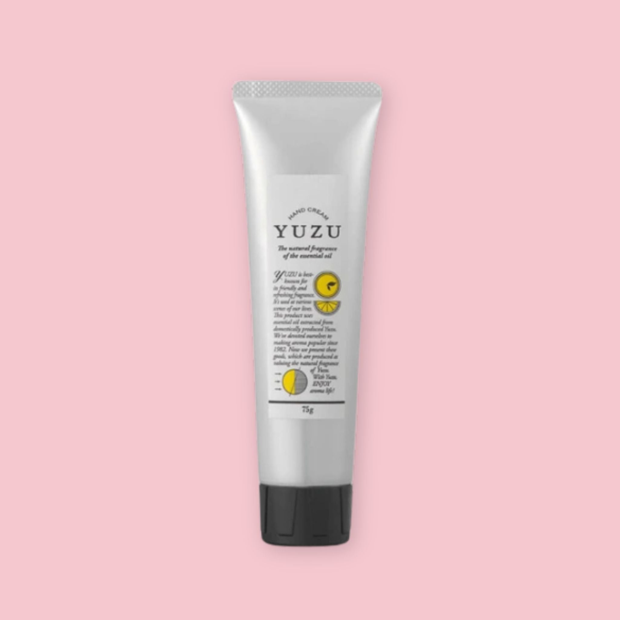 Silver tube of yuzu hand cream with a black cap, shown upright on a pink background.