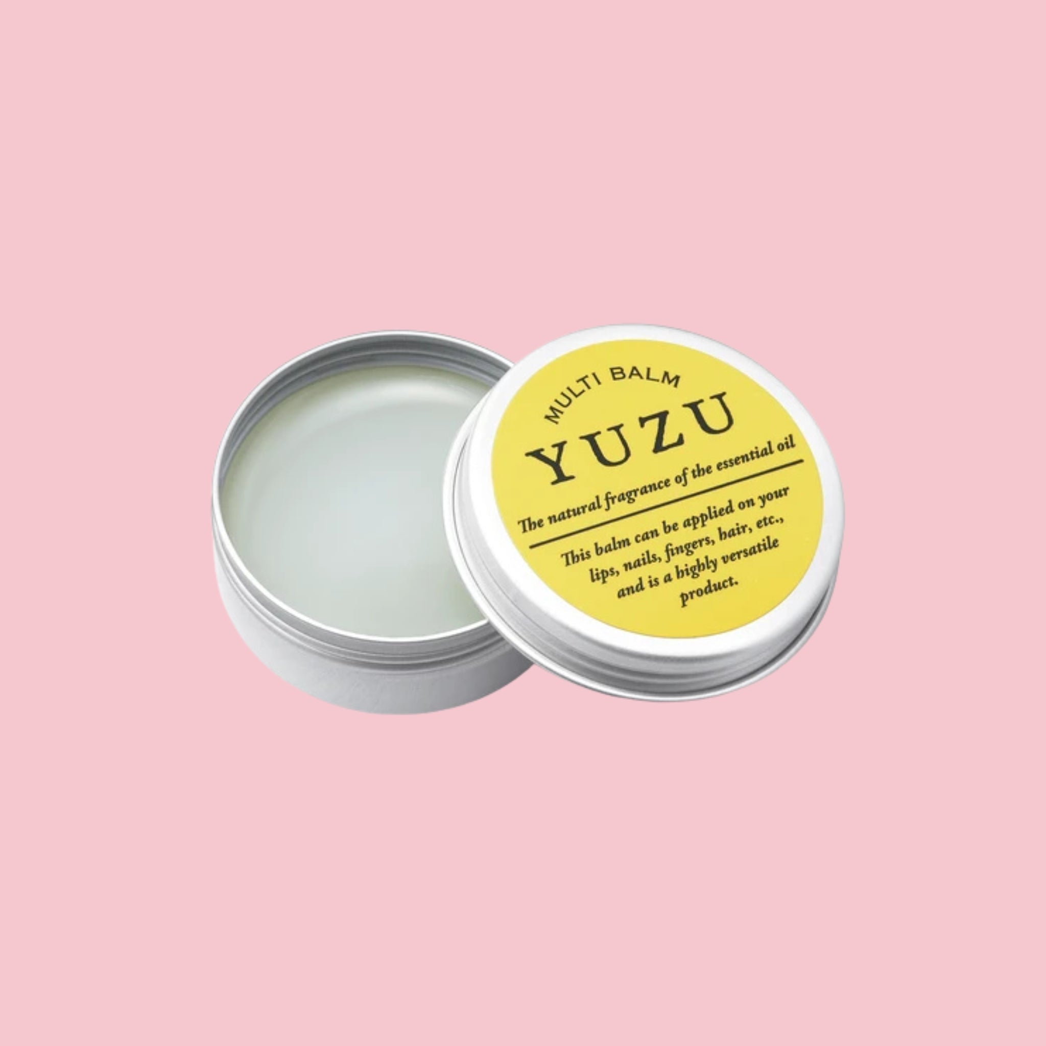 Open tin of yuzu multi balm with a yellow-labeled lid, shown on a pink background.