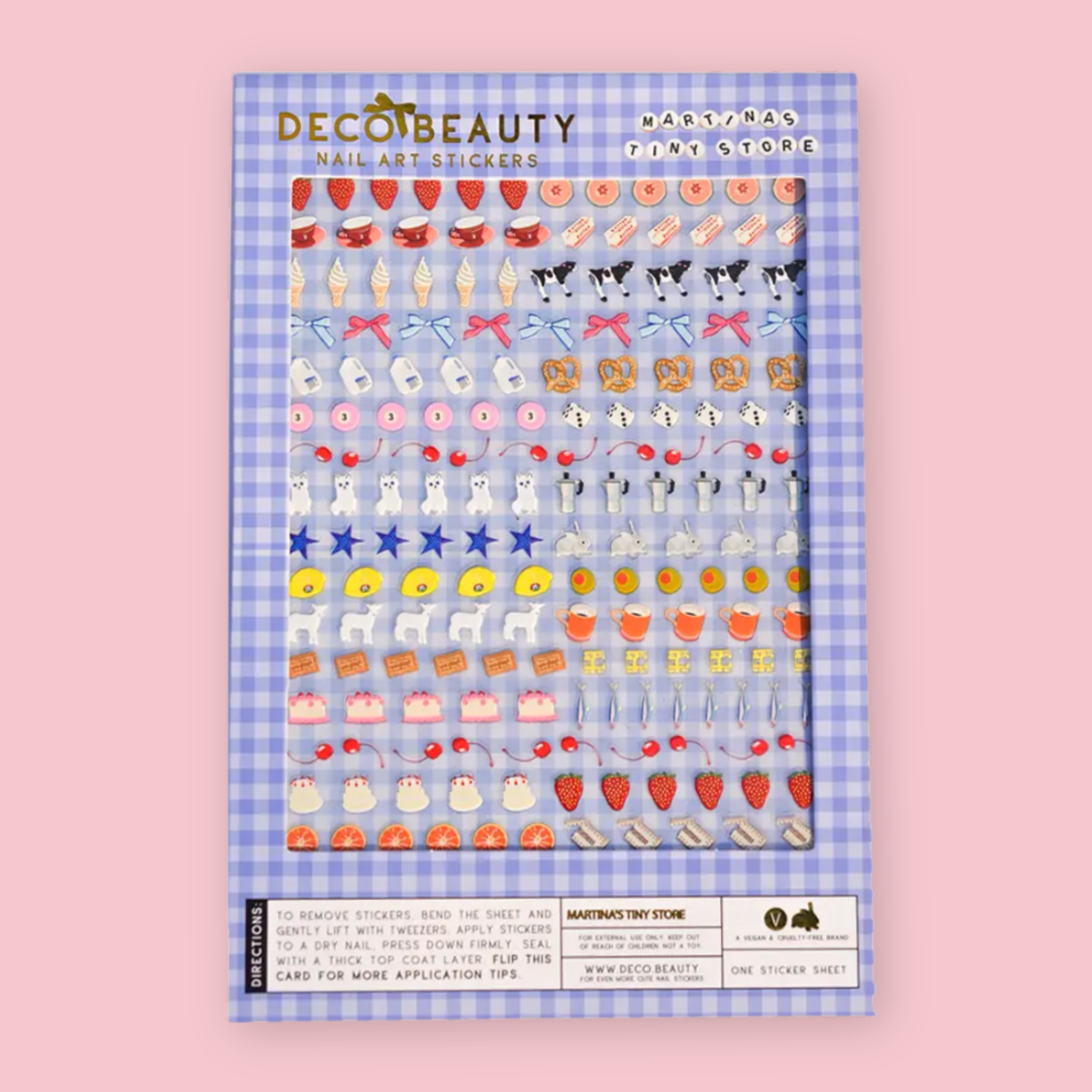 Deco Beauty Martina's Tiny Store nail art sticker sheet packaging on a blue gingham background, with stickers depicting an eclectic mix of motifs including strawberries, teacups, cakes, soft serve cones, cows, bows, pretzels, cats, espresso pots, stars, lambs, and cherries.