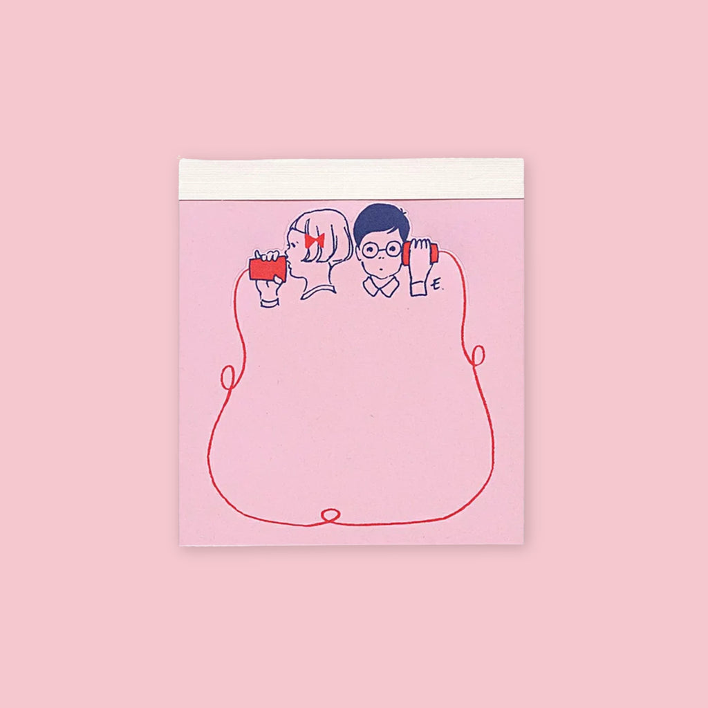 Die-cut memo pad featuring illustrated boy and girl sharing a red string on a pink background