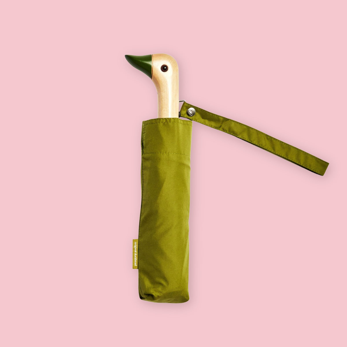 Olive green folding umbrella with duck-shaped wooden handle and matching wrist strap on a pale pink background.