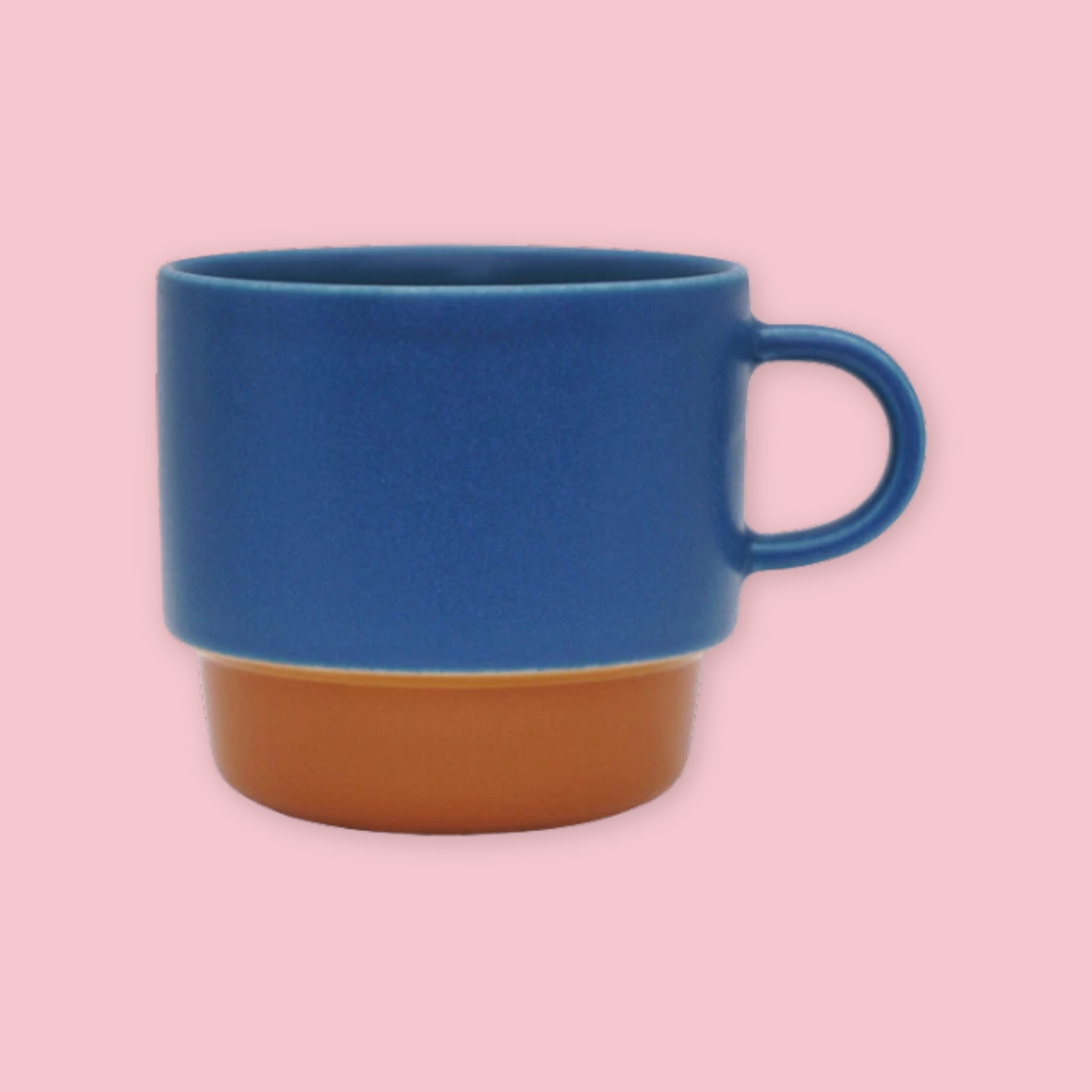 El Commun Mug in blue with brown base on a pink background.