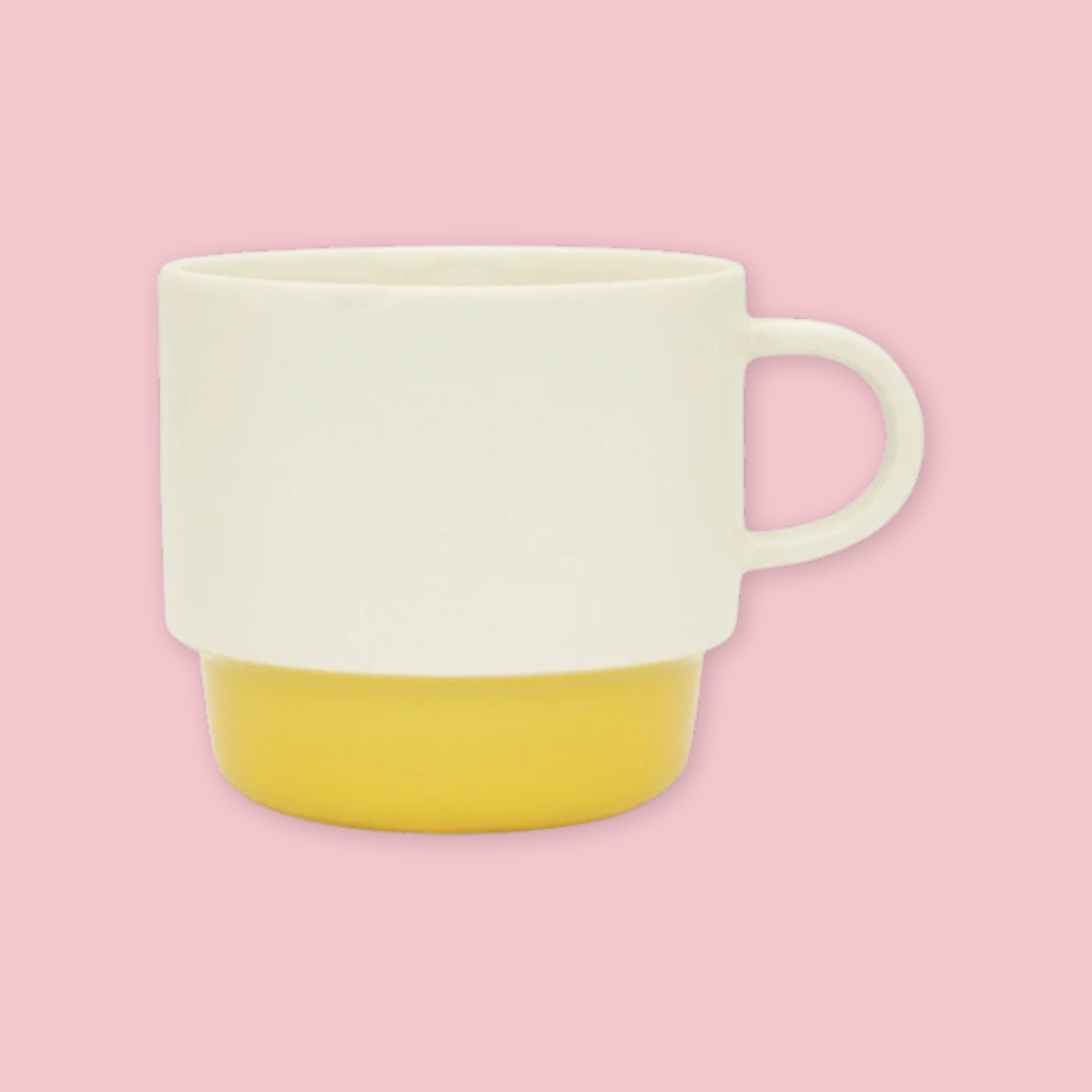 El Commun mug in cream with yellow base on a pink background