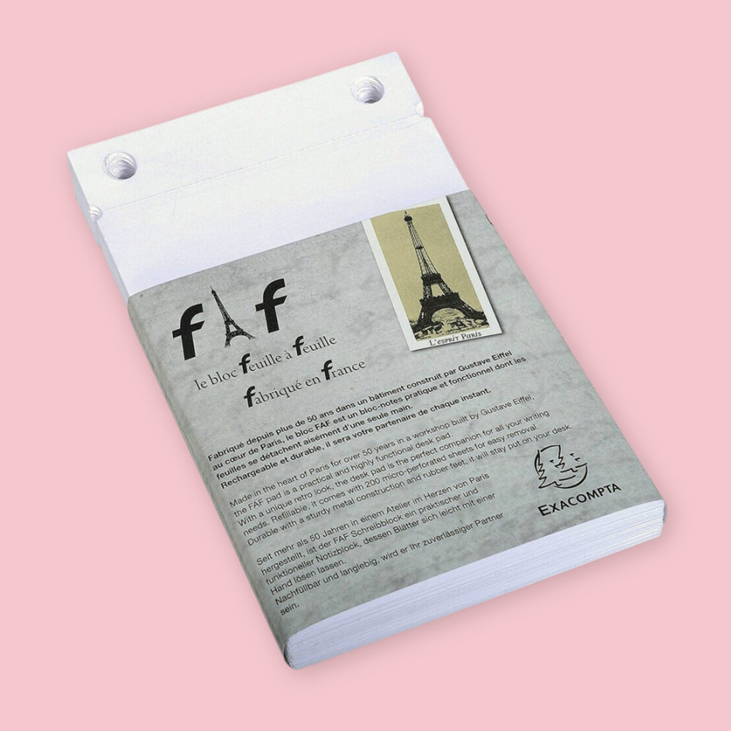 Exacompta Bloc FAF blank refill paper for the 4 x 6 brass desk pad, shown in its gray packaging with FAF logo, Eiffel Tower illustration, and French and German product description, on a pink background.