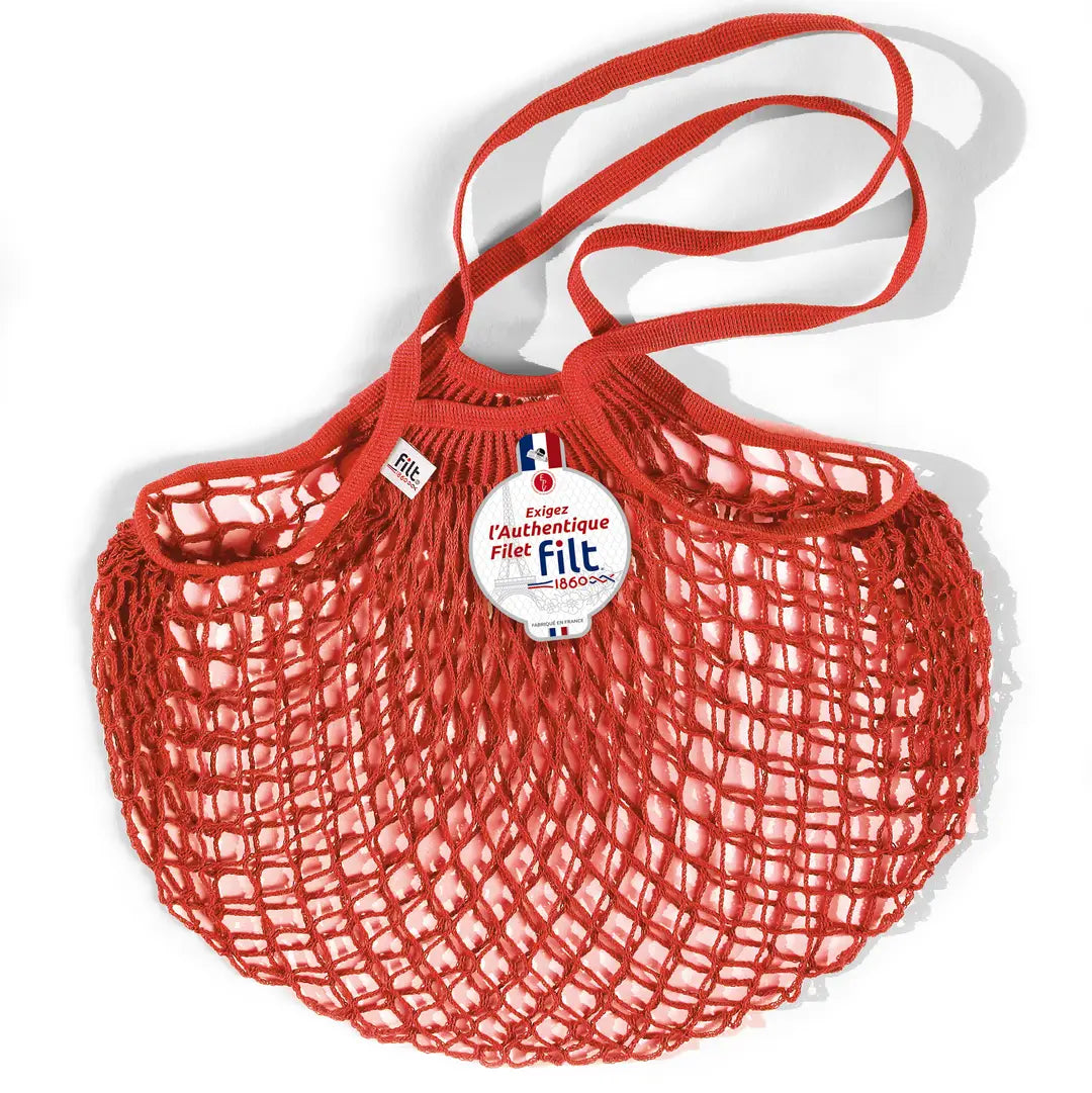 Filt French market mesh tote bag in red with long handles and round brand tag, shown on a white background.