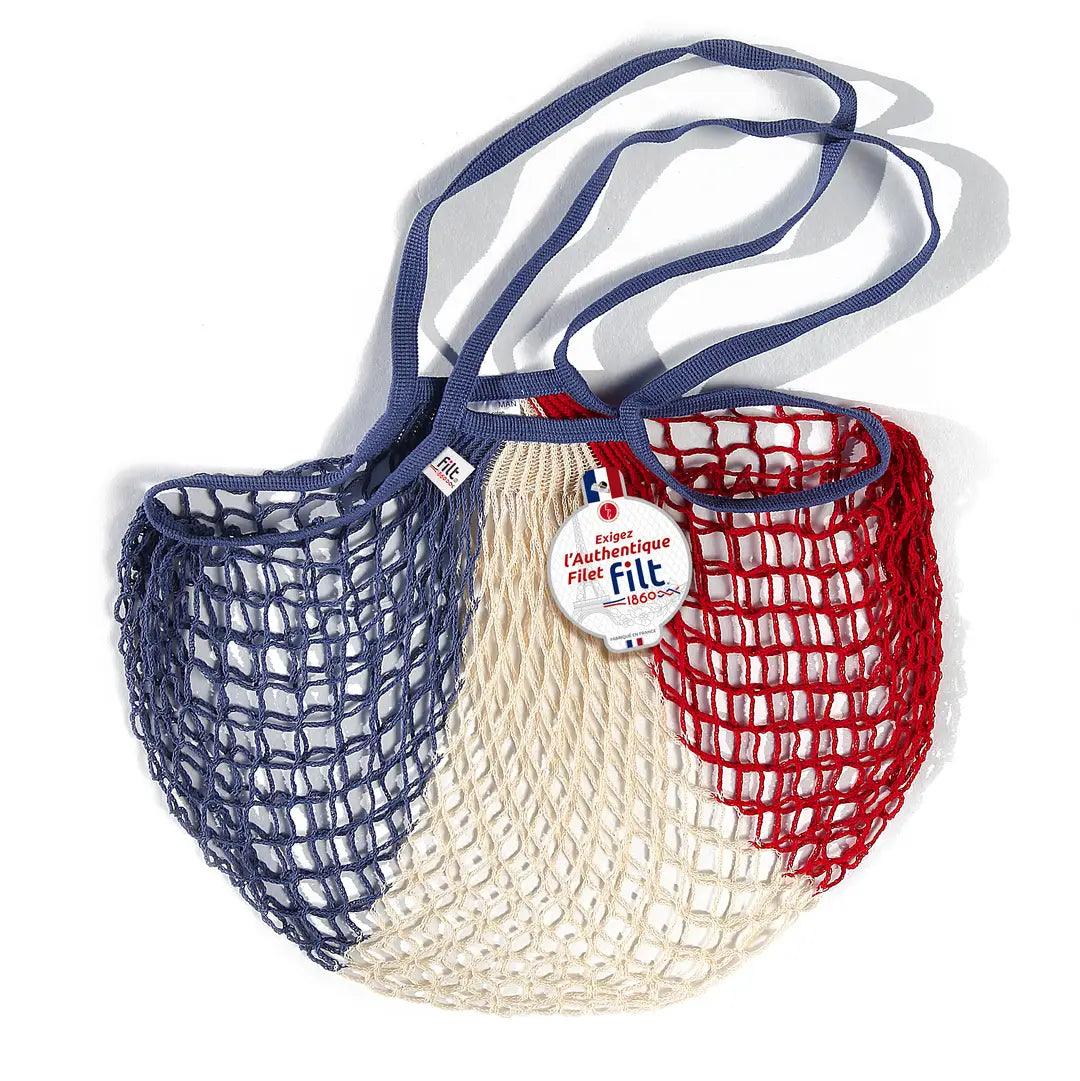 Filt French market mesh tote bag in blue, cream and red with long handles and round brand tag, shown on a white background.