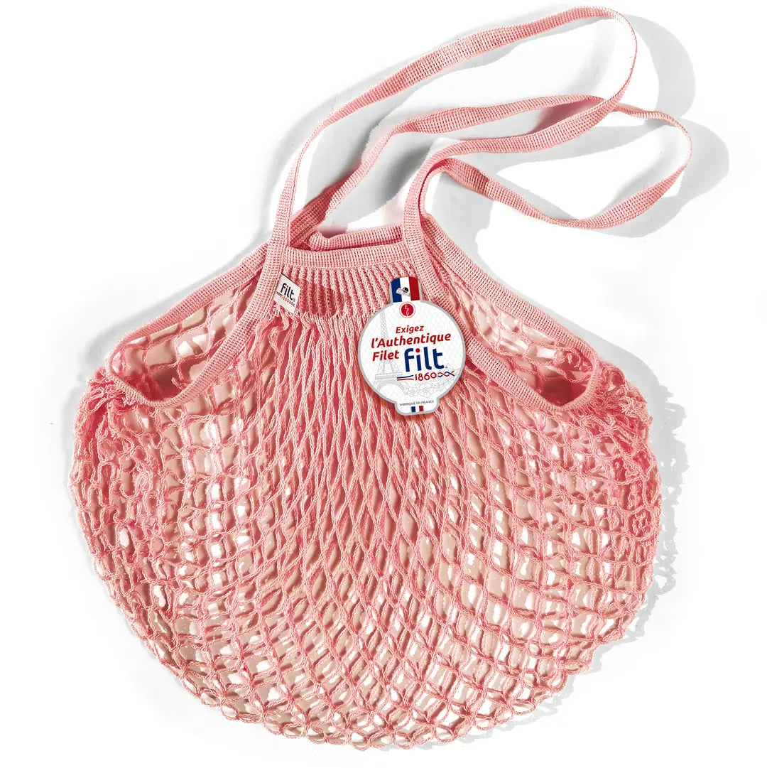 Filt French market mesh tote bag in pink with long handles and round brand tag, shown on a white background.
