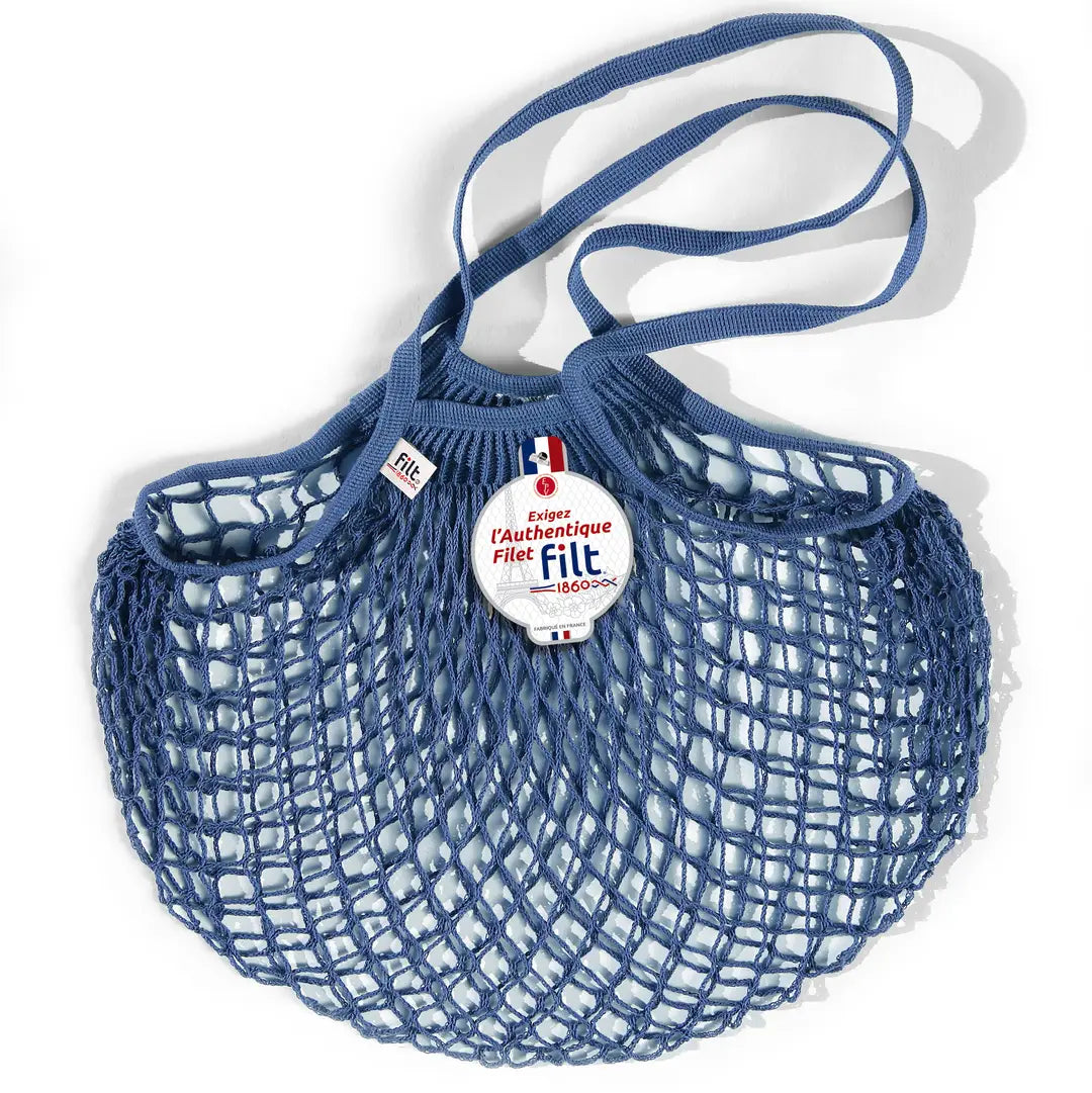 Filt French market mesh tote bag in blue with long handles and round brand tag, shown on a white background.