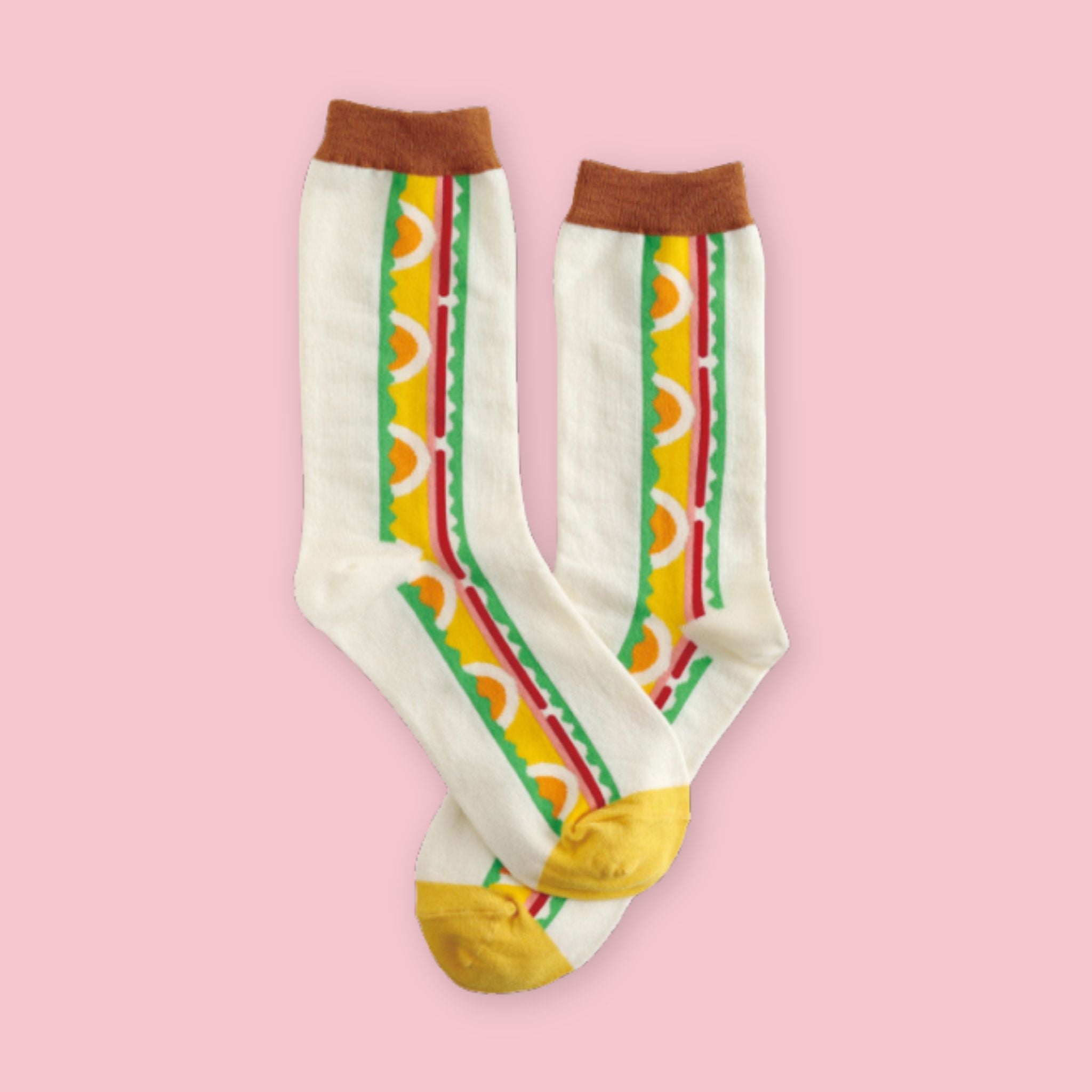 Cream crew socks featuring a colorful Japanese egg sandwich motif with layered bread, egg, lettuce, and tomato design, displayed on a pastel pink background.