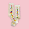 Garapago Socks in Fruit Sando style featuring colorful illustrated fruit pattern on cream crew socks on a pink background